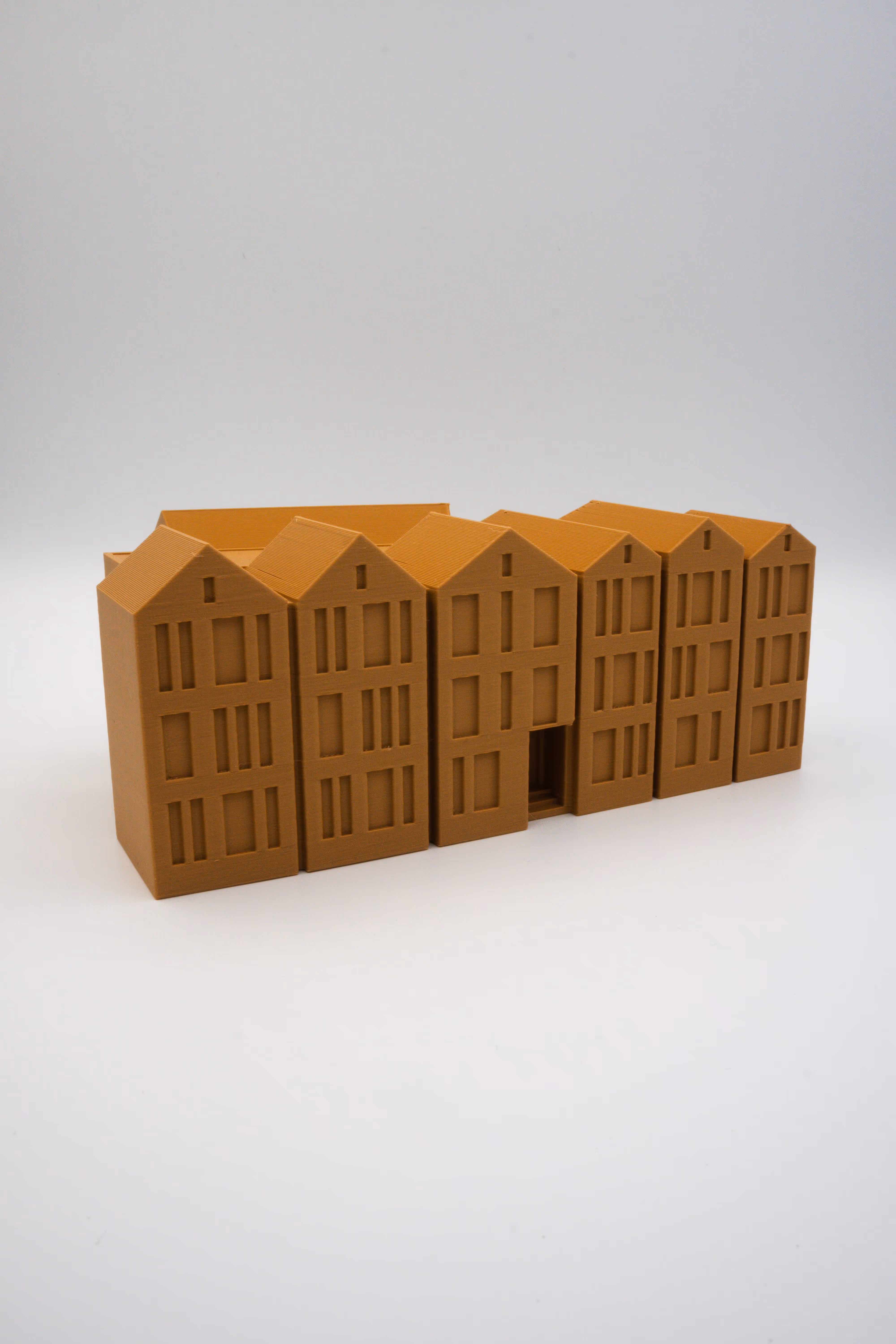 Bruin 3D-geprint model van een rij stadswoningen op witte achtergrond