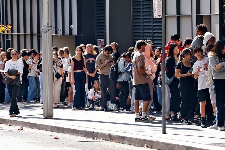 People lining up outside a popular retail business, demonstrating how social proof and strong brand positioning influence customer choice.