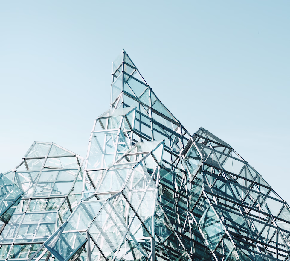 Photograph of an angular glass and steel building against a blue sky