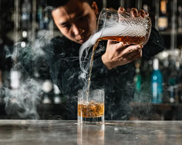 Pouring smokey whiskey into a glass