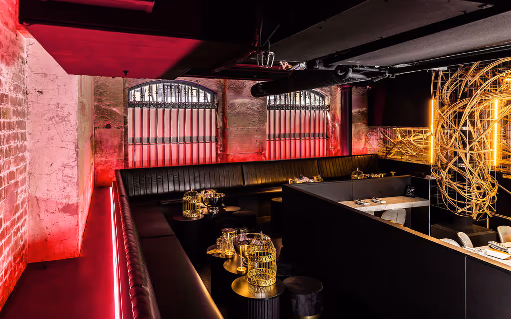 Night-time mezzanine shot with dramatic red lighting at Hustlers Sydney, illustrating vibrant after-dark event atmosphere.
