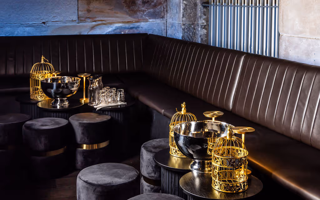 VIP lounge booth with plush stools and signature gold birdcage bottle service at Hustlers Sydney.