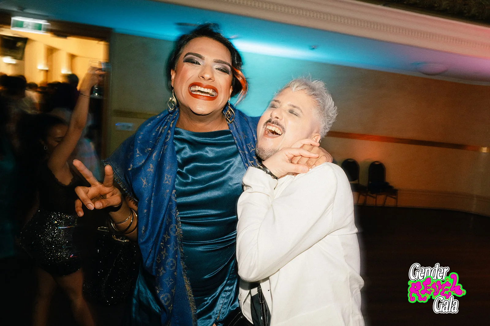 Two guests laughing and dancing together at the Gender Revel Gala