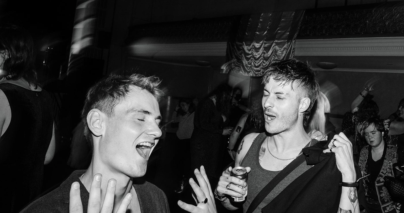 A black and white photo of two guests singing along on the dance floor