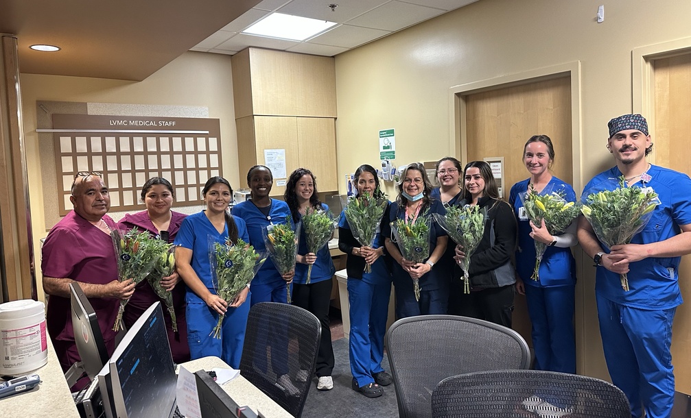 Group of nurses in scrubs holding bouquets at Lompoc Valley Medical Center during Petal It Forward 2026.