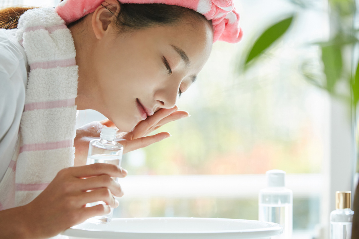 A woman uses toner in her nightly skincare routine. 
