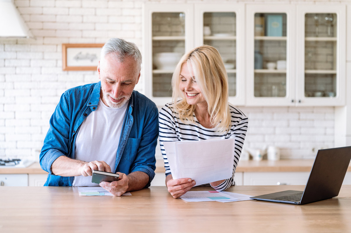 An elderly couple looks through their insurance plan options.