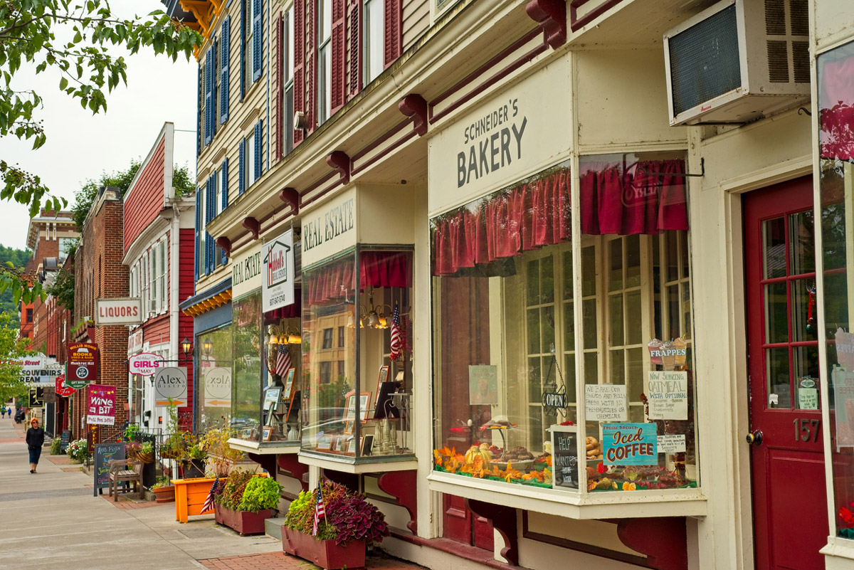 A small town street is filled with shops and a local pharmacy.