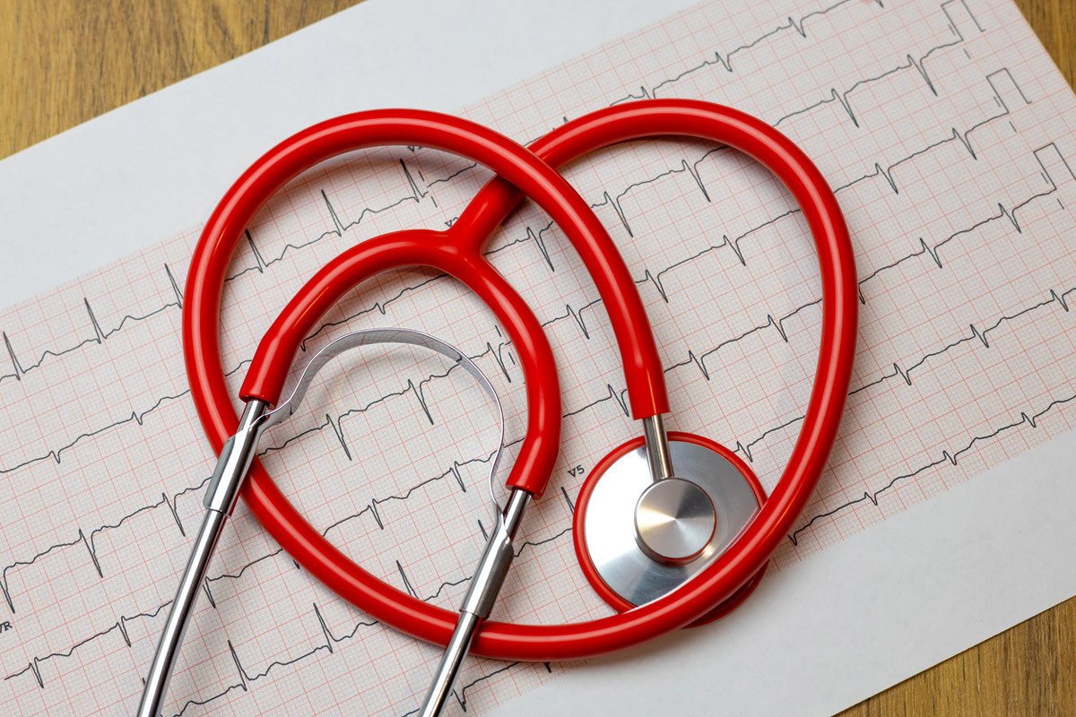 A stethoscope is laid out in the shape of a heart over medical charts.