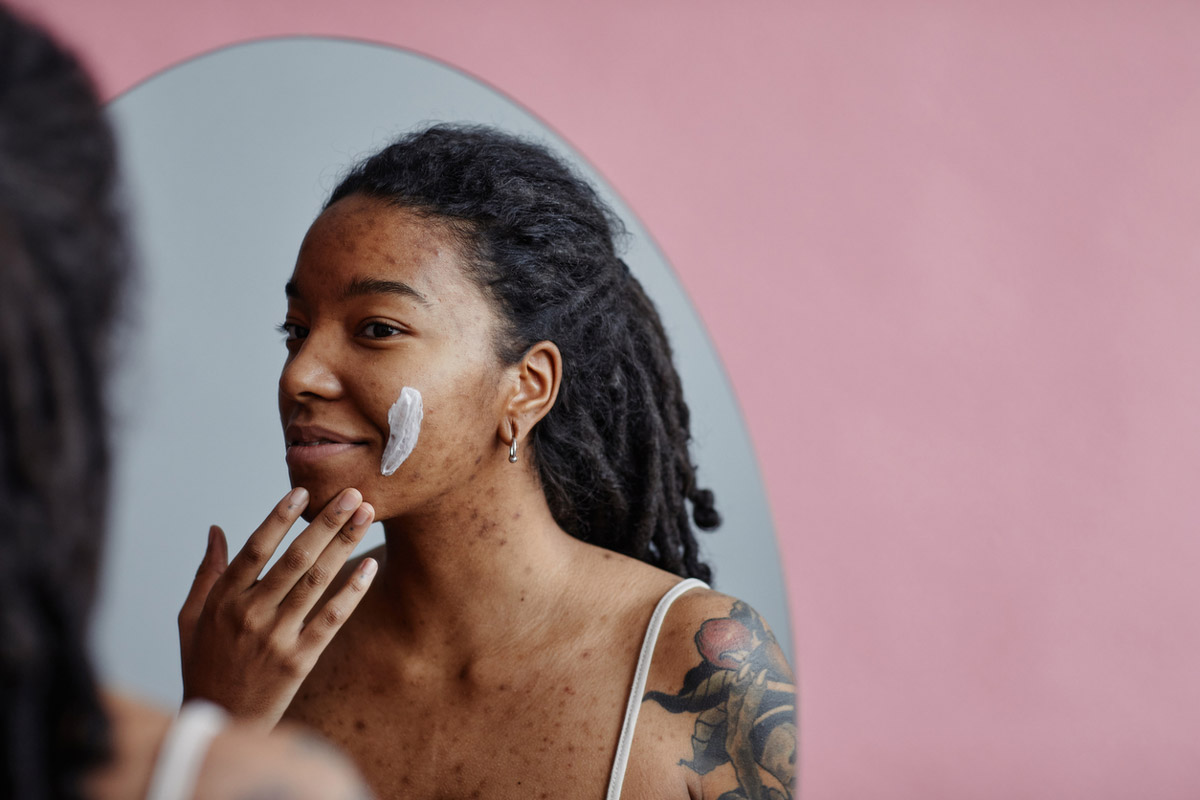 A young woman washes her face as a part of her nightly routine to avoid acne scarring.