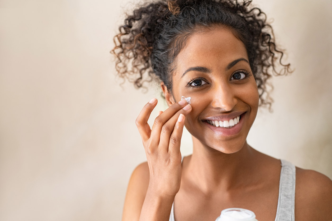 A middle-aged woman applies her mightly vitamin C treatment to help prevent fine lines and signs of aging. 
