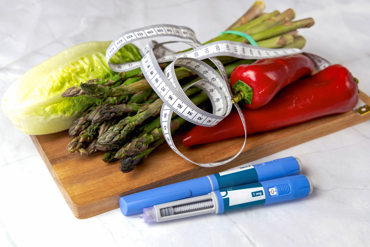 A GLP-1 medication is displayed with vegetables and a tape measurer.