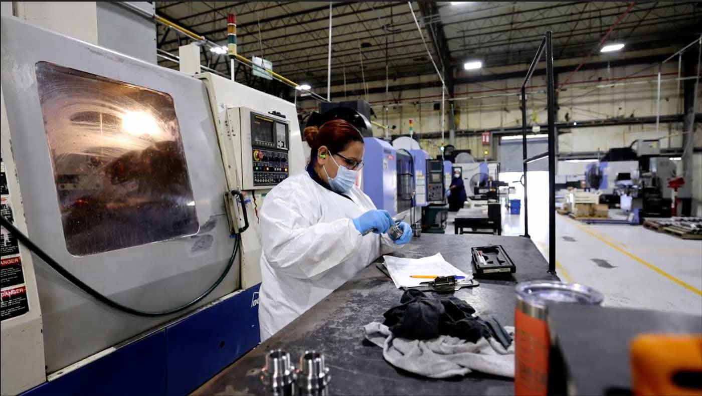 A frac plug and downhole completion tools manufacturing worker meticulously inspects the quality of a product.