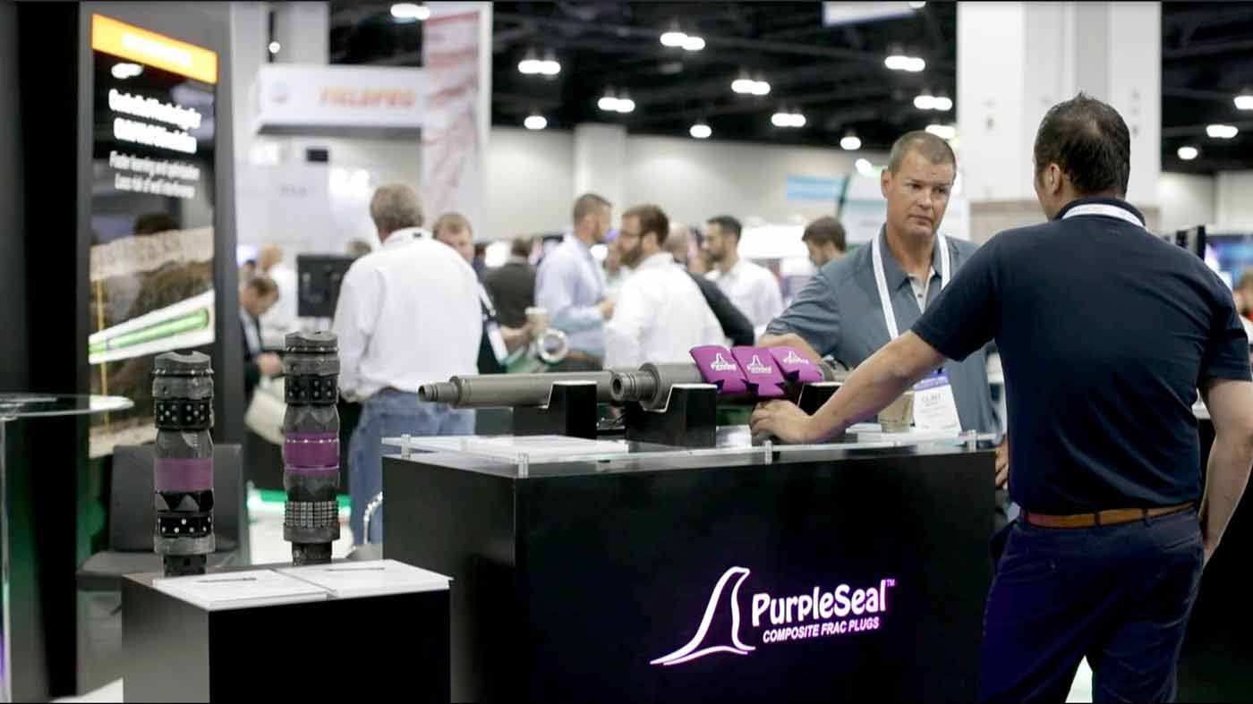 Photo of Repeat Precision staff at a trade show behind a PurpleSeal-branded booth