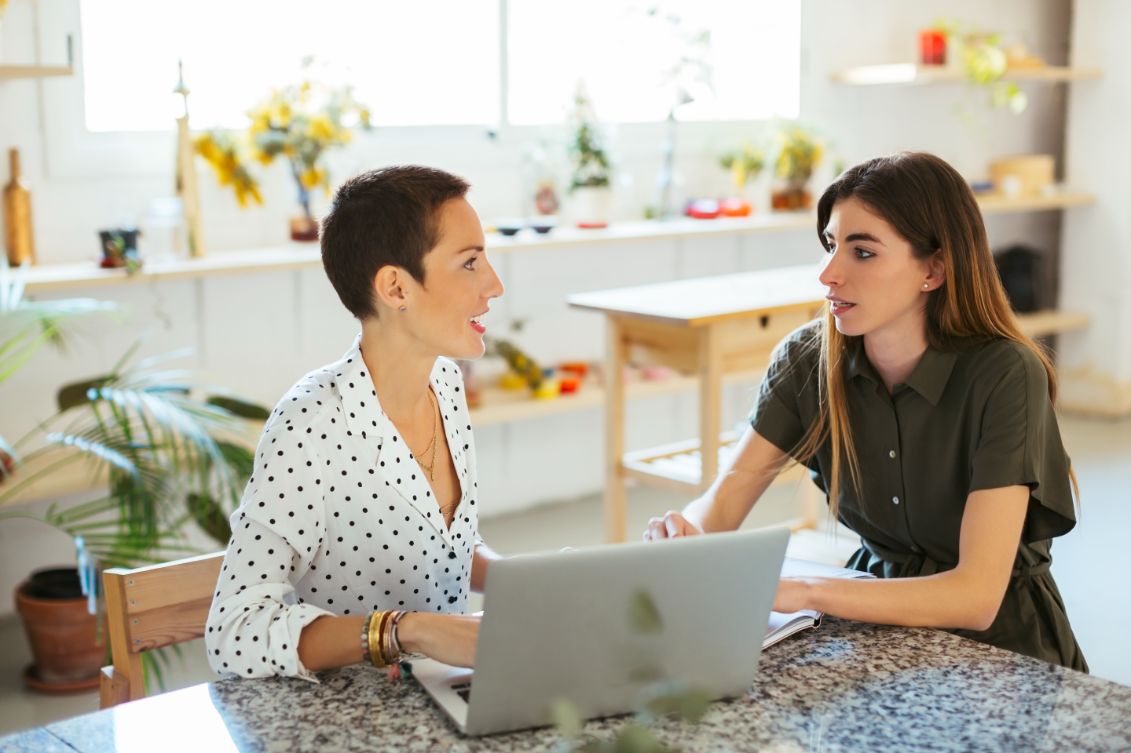 two women are sitting together at a table