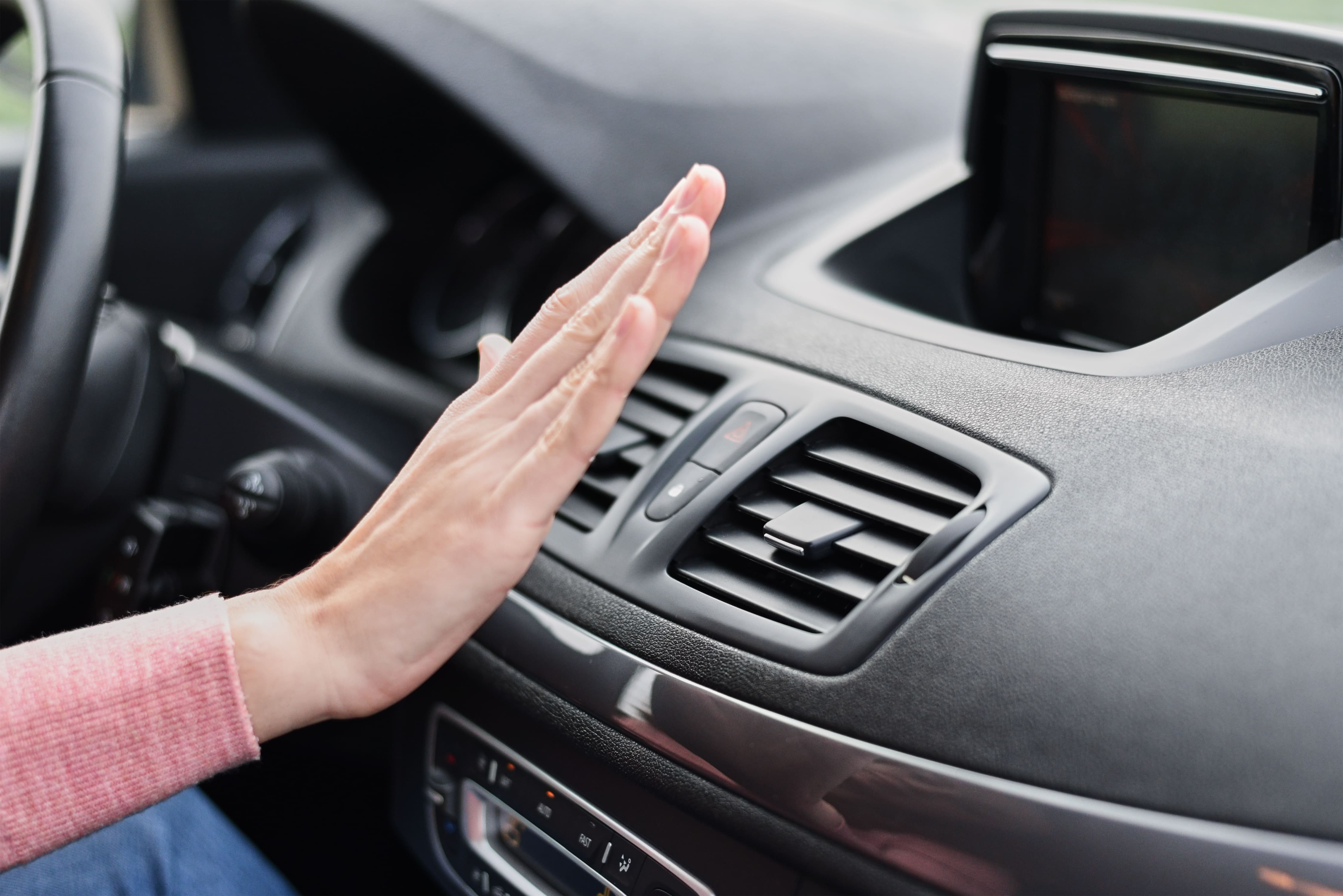 Woman checking car air conditioning