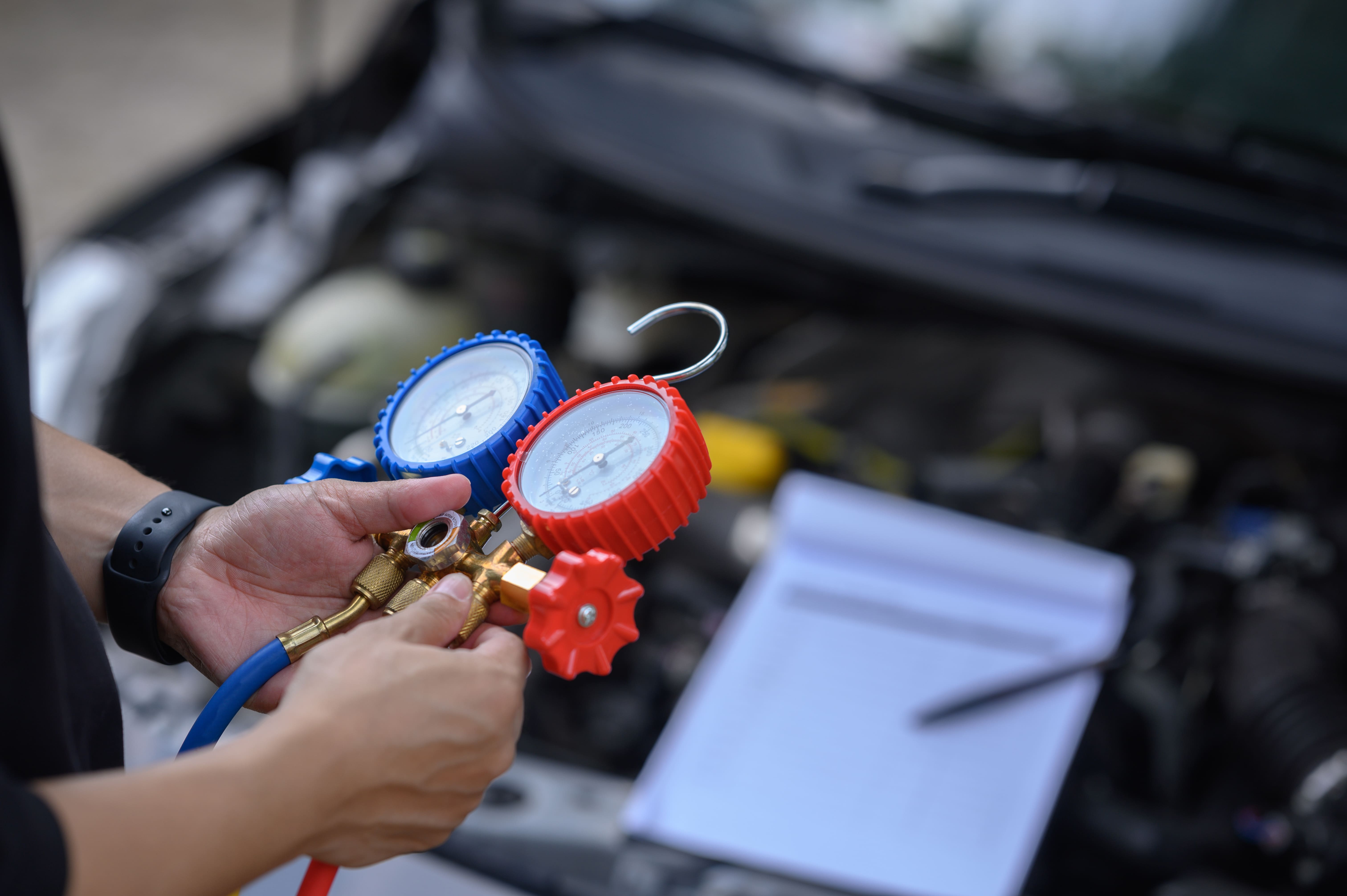 Man checking car air conditioning pressure