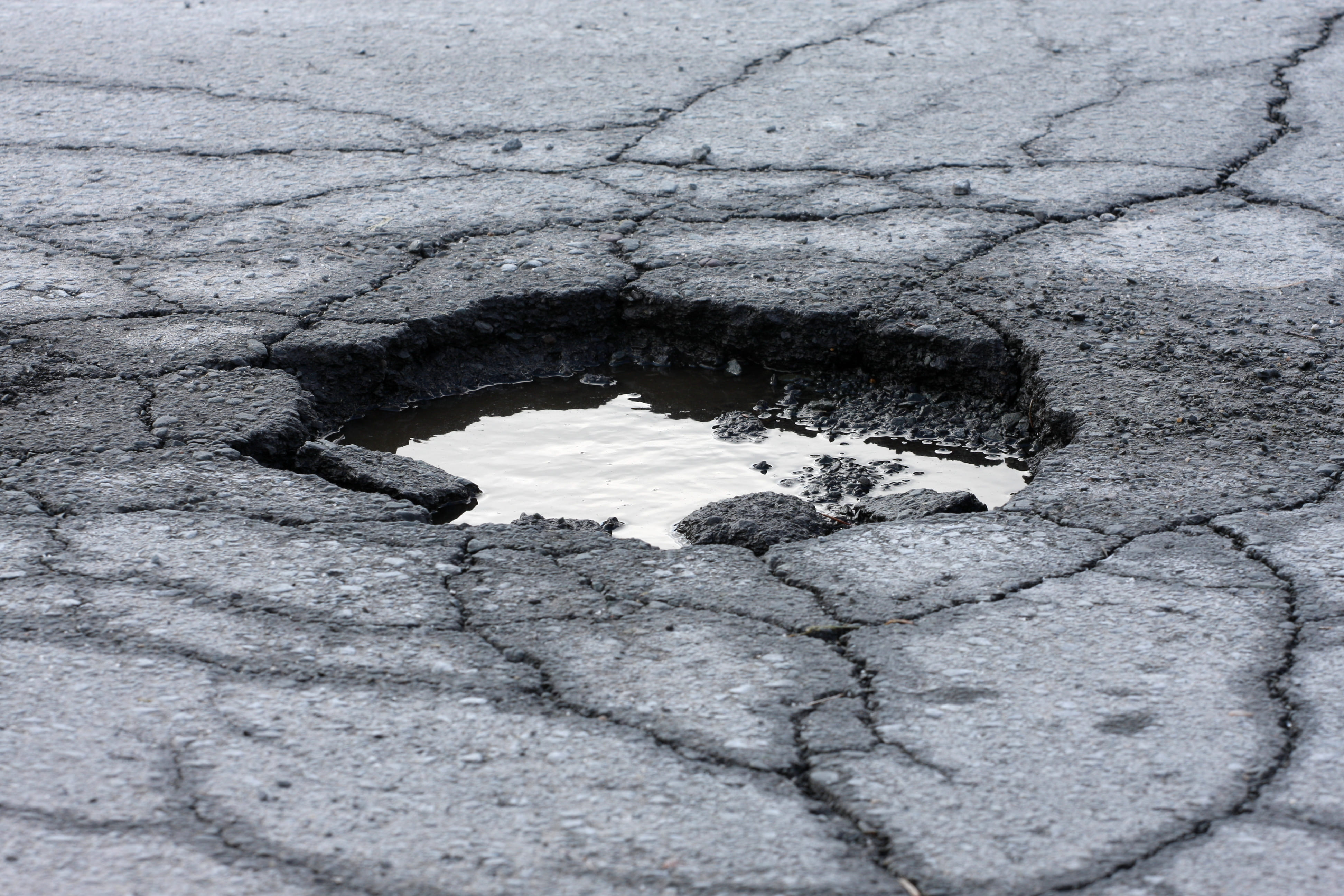 A pothole in the asphalt.