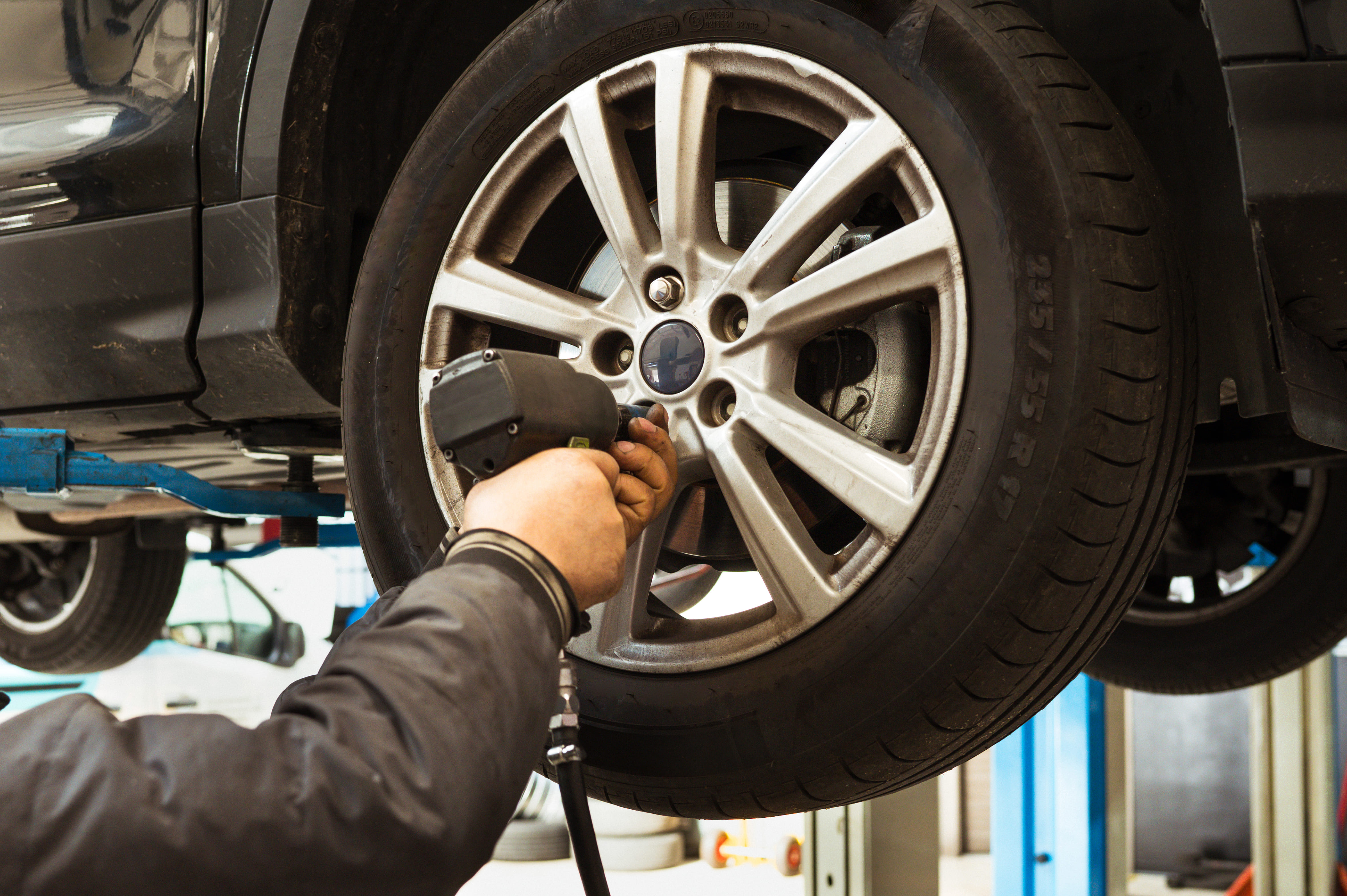 A man removing a car wheel.