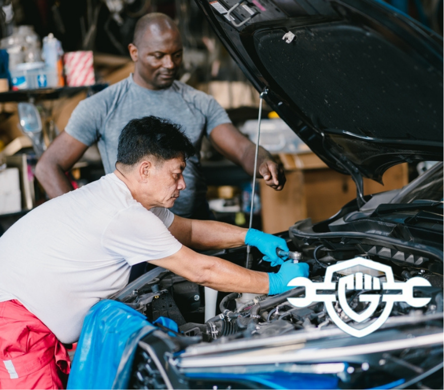 Mechanic team men working together to service fix engine problem in car auto workshop