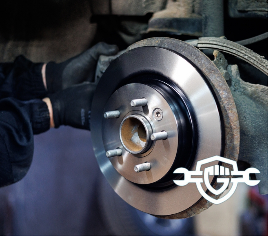 Mechanic replacing car brake disc in auto workshop, Close-up of a mechanic's hands installing a new brake .