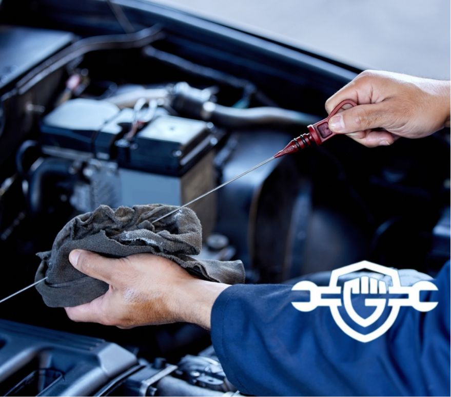 mechanic checking the oil levels in a vehicle