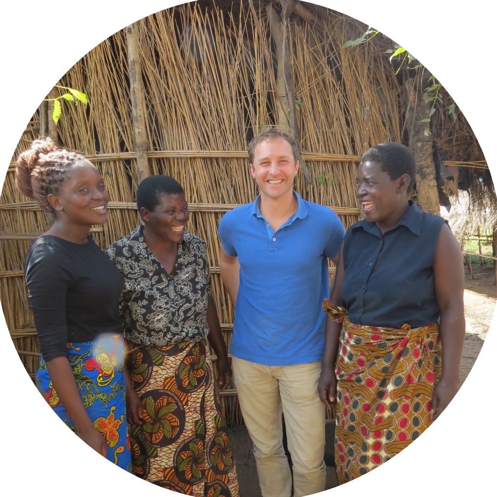 3 women and 1 man standing and smiling and laughing together