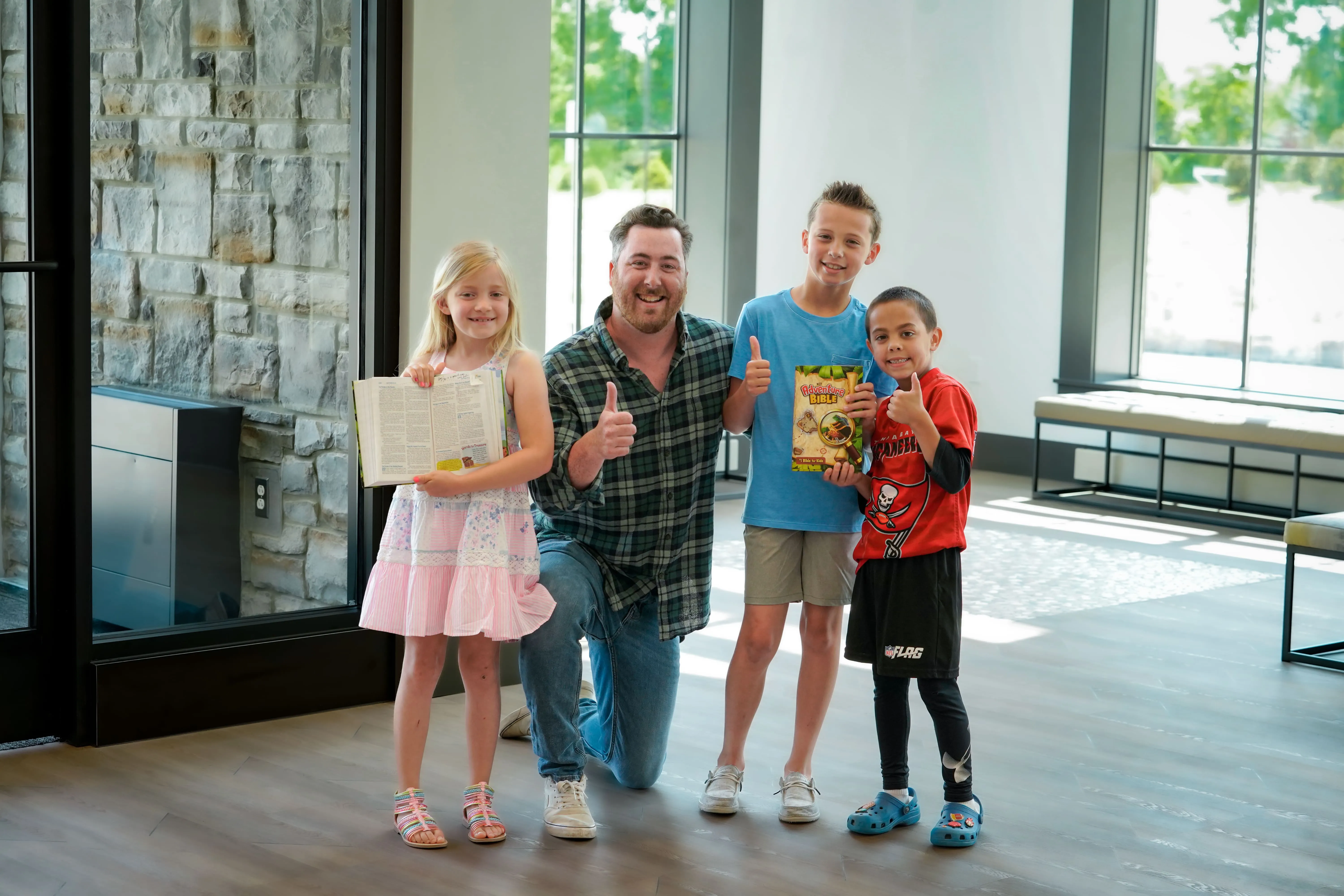 Family giving thumbs up in the GRACE lobby