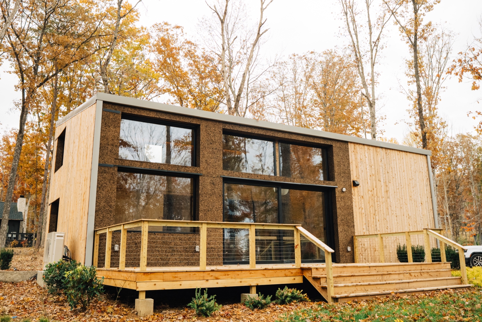 Exterior view of a completed Aera home with warm wood siding and large windows.