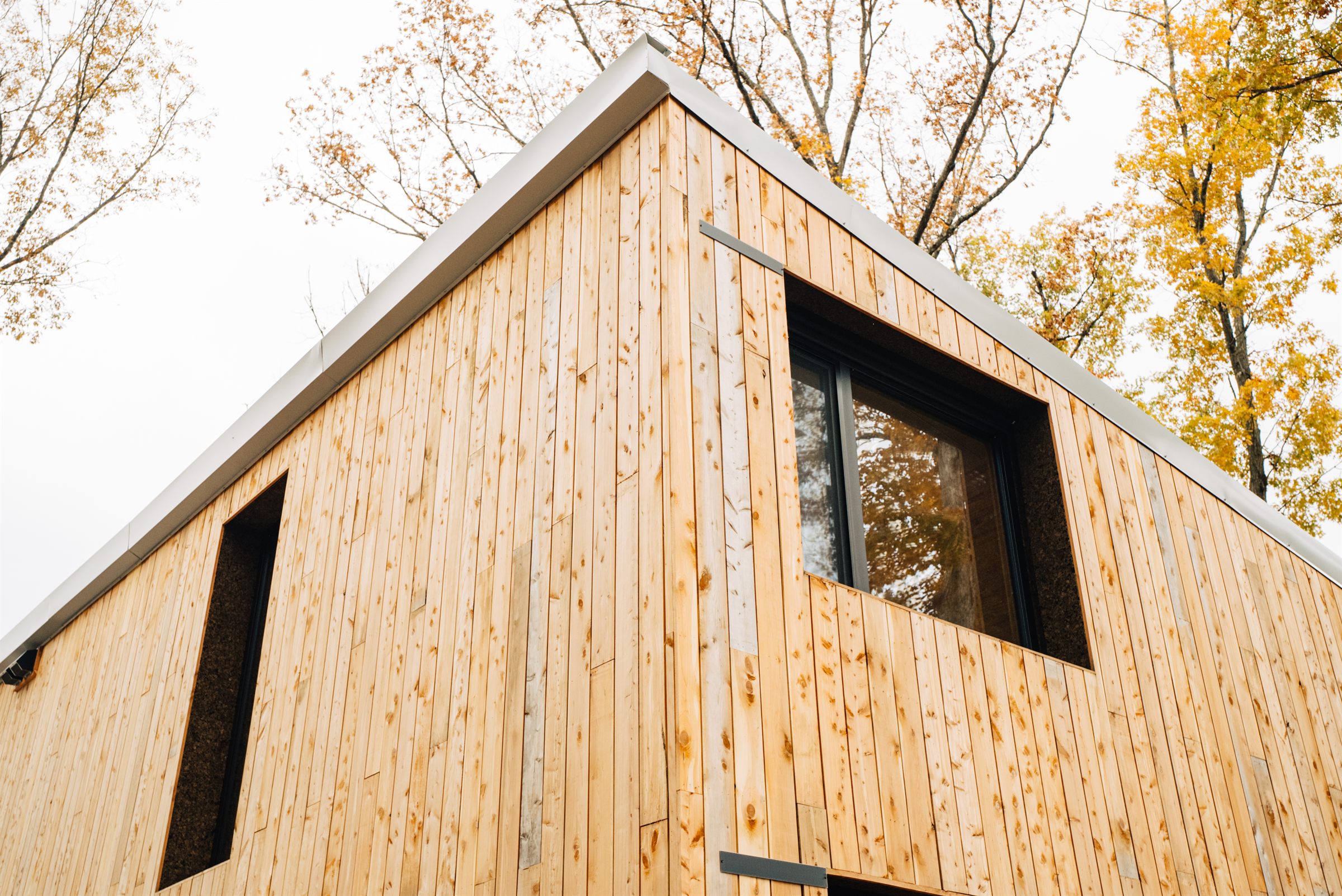 Side elevation of a Waters Edge home with large windows and wood siding
