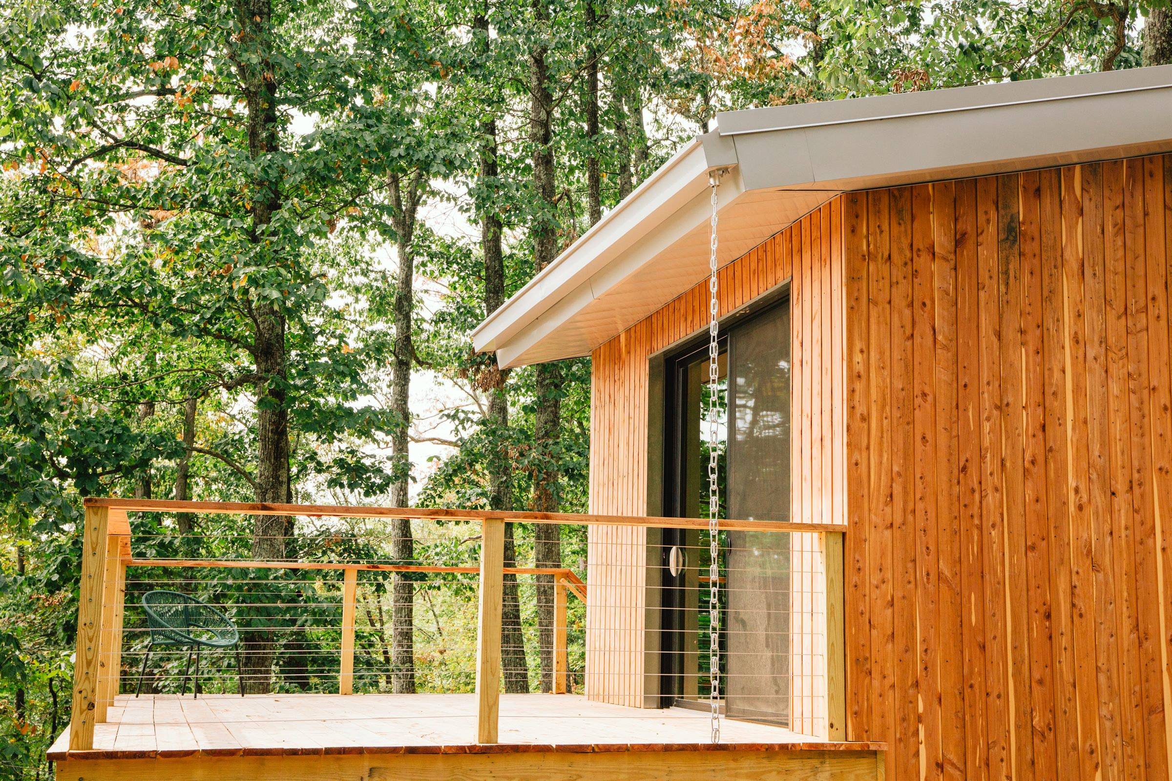 Finished cabin exterior with wood cladding nestled in trees