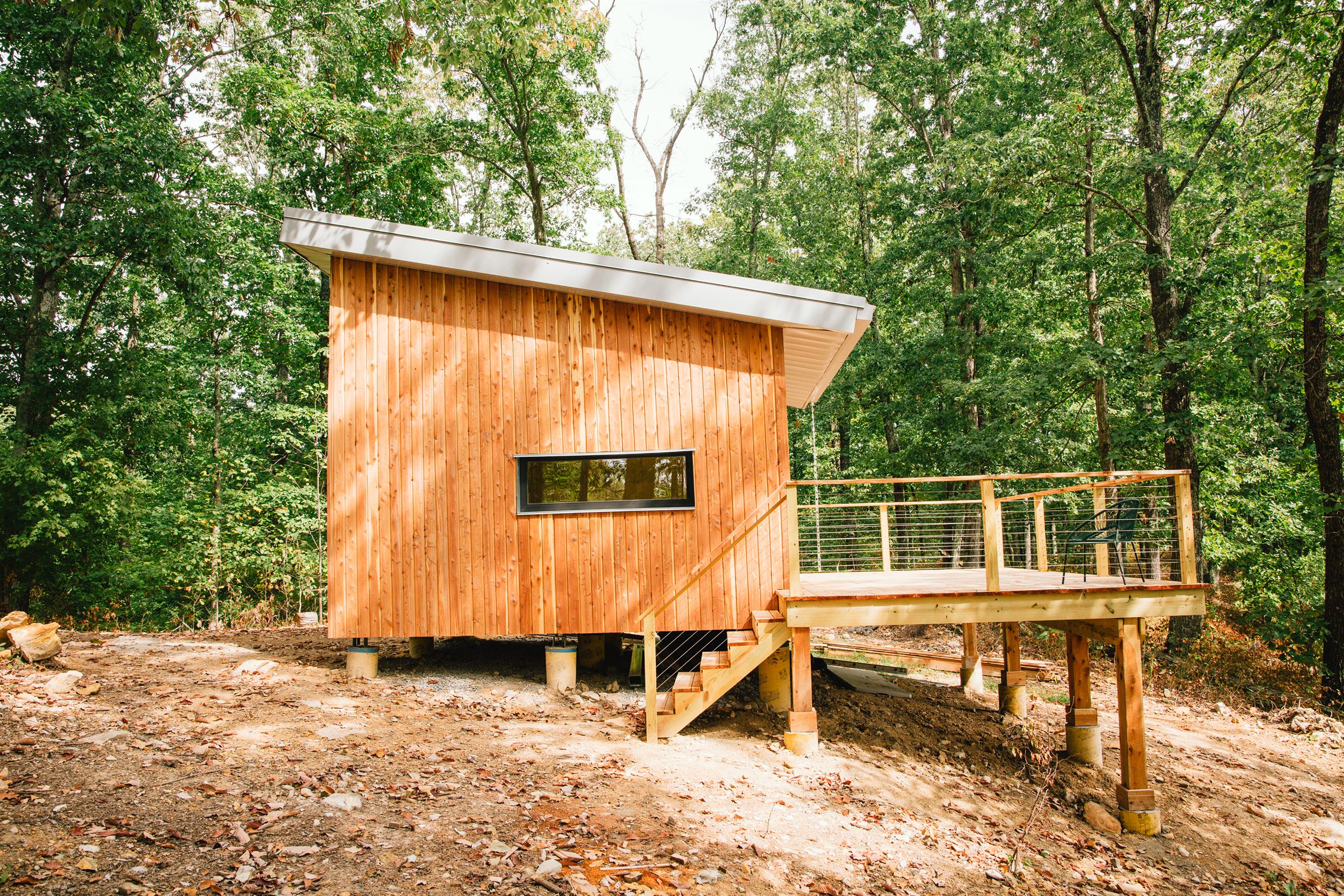 Cabin project exterior with deck framing overlooking woods