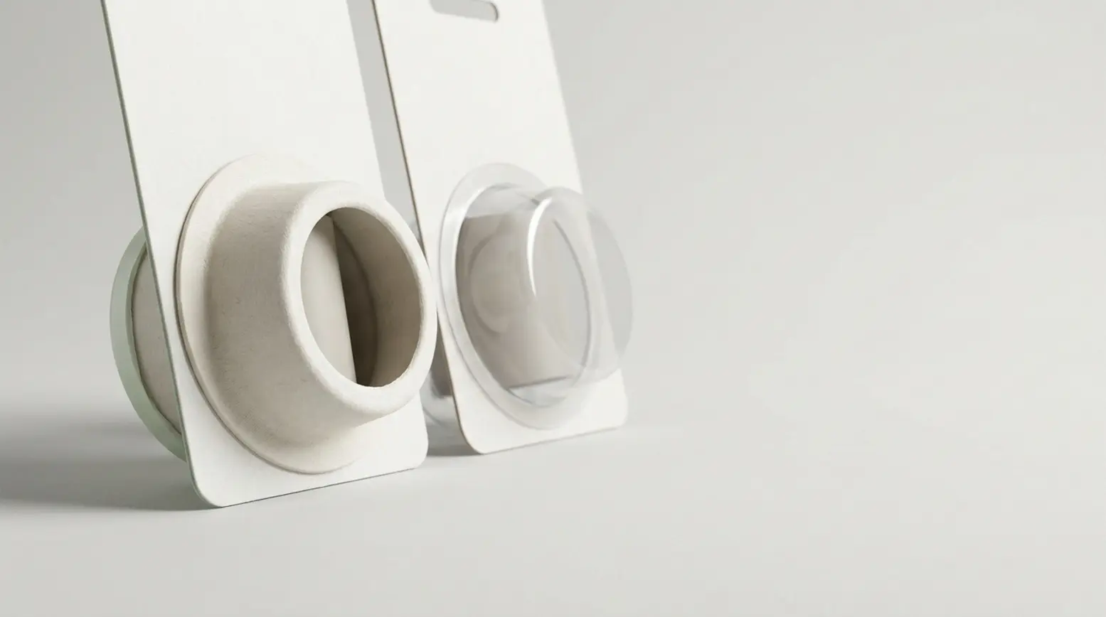 Editorial image showcasing paper and plastic blister packaging samples on a clean studio surface.