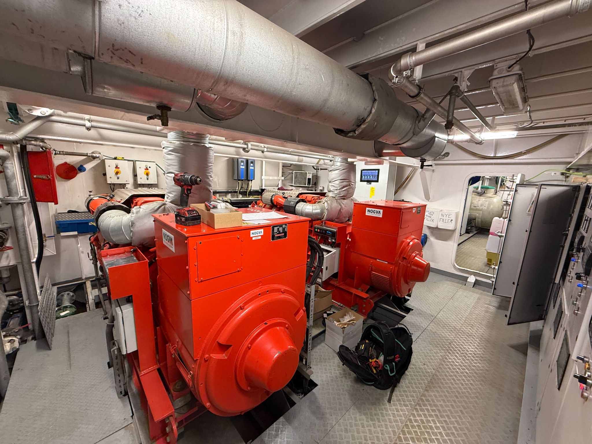 Engine room on the wellboat Selma with two large red diesel generators and technical installations