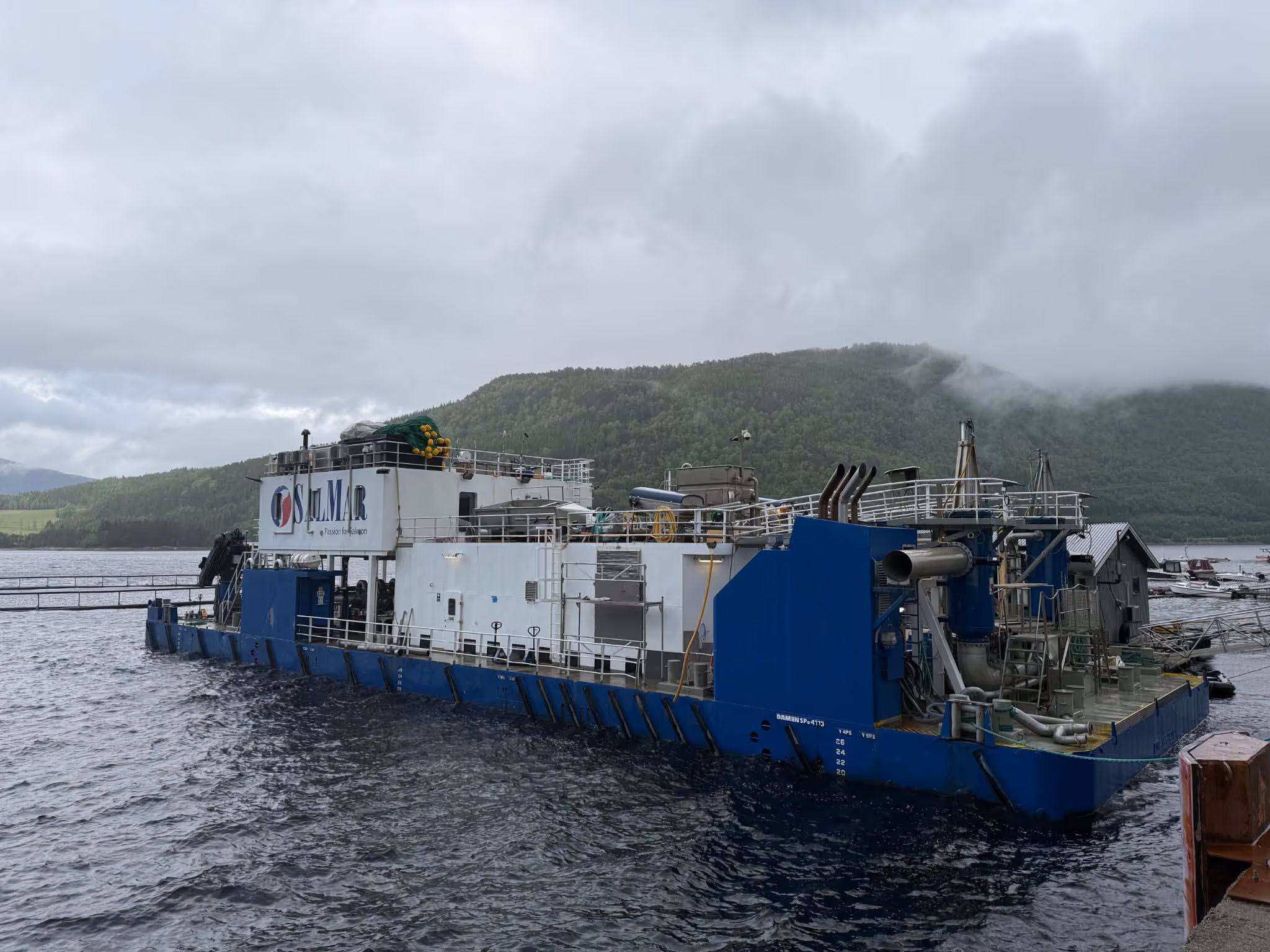 Brønnbåten Selma ligger ved kai i overskyet vær, med tekniske installasjoner synlige på akterdekket.