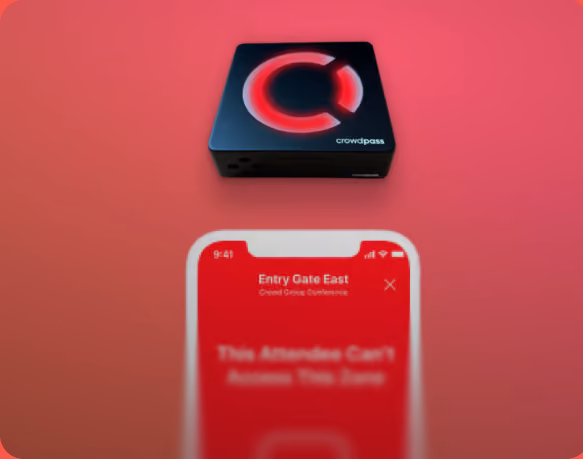 Black square device with a glowing red 'C' logo labeled 'crowdpass' above a smartphone showing a red screen with the message 'Entry Gate East: This Attendee Can't Access This Zone' on a red background.
