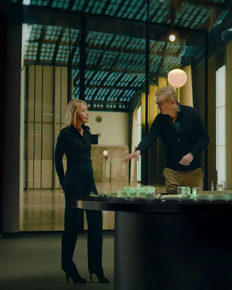 Two people at a scale model in an industrial hall, from the brand film for Advario