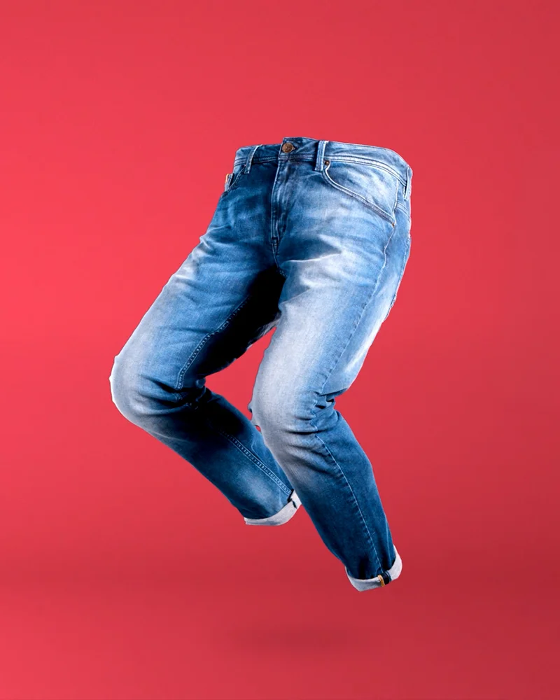 Floating pair of jeans against a red background, from the brand video for Garcia x Radygo