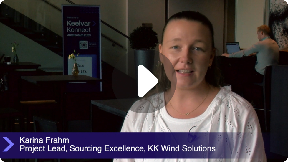 Karina Frahm, Project Lead at KK Wind Solutions, speaking in an office setting with a Keelvar Konnect Amsterdam 2023 banner in the background.
