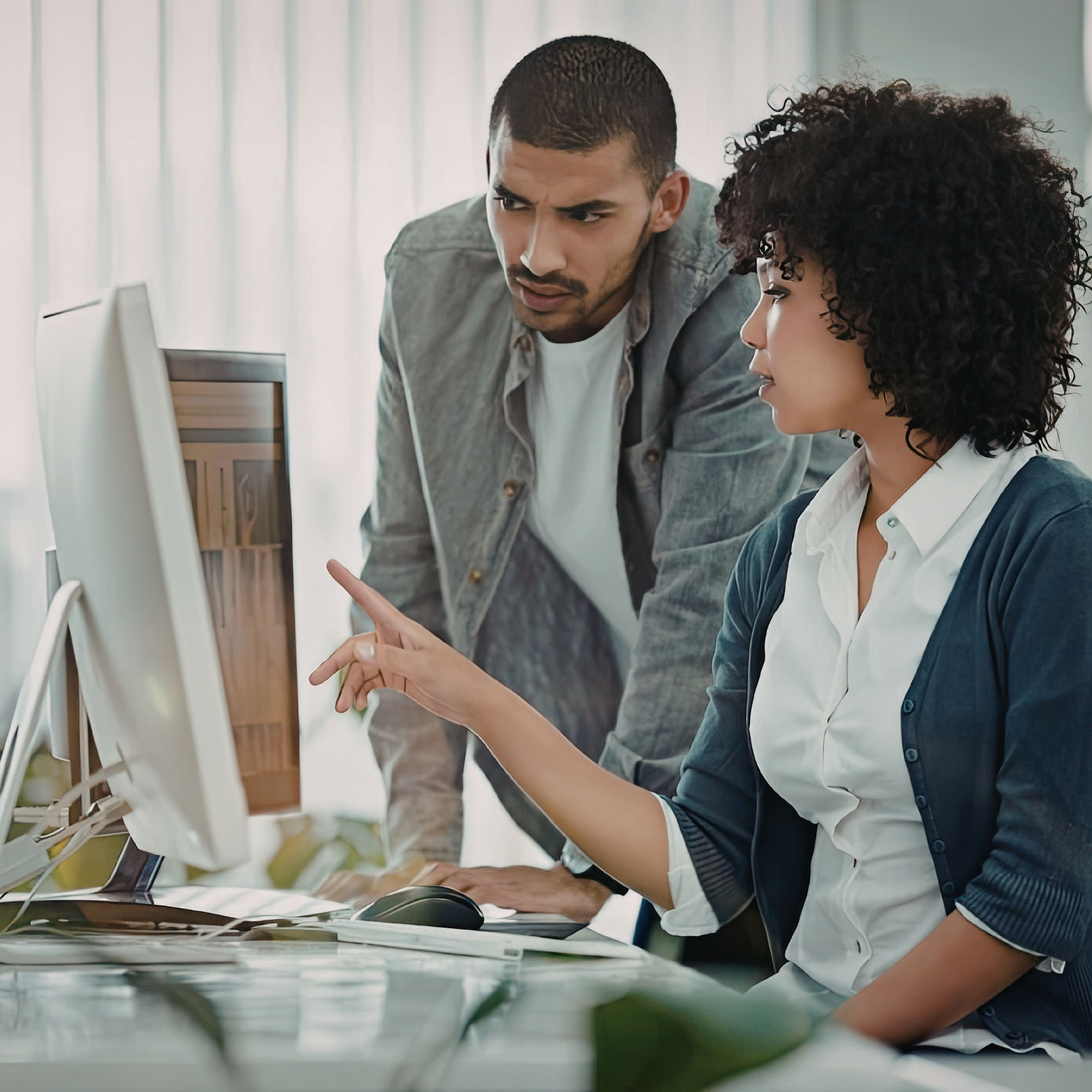 Two people collaborating over a screen