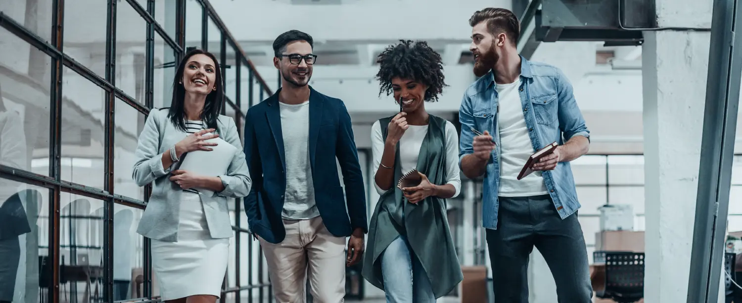 A group of young business people walking and talking to one another