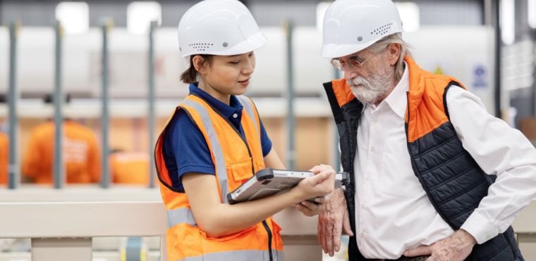 Employees from two different generations working together in a warehouse