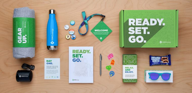 An Employee Appreciation Day swag box created by O.C. Tanner’s custom awards team which includes branded merchandise, personal notes, and treats/snacks for employees to enjoy.