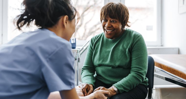 A healthcare worker and a patient in an exam room
