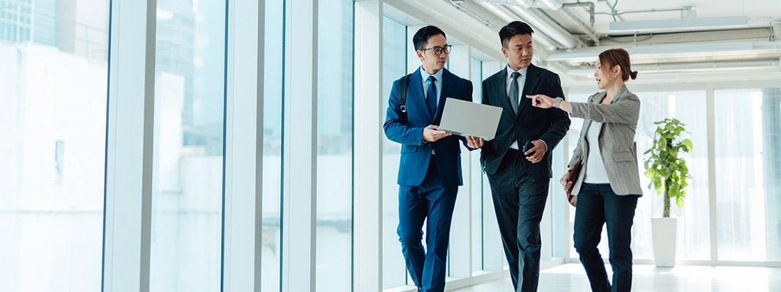 Business people having a discussion while walking in an office hallway