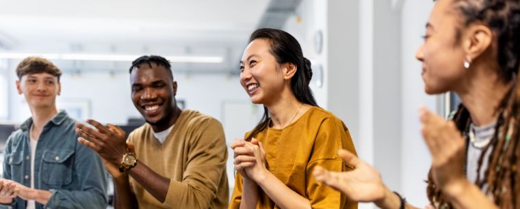 Employees sharing a recognition moment in a meeting