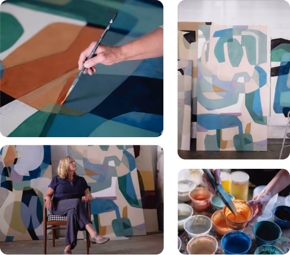 Artist painting abstract shapes, seated beside her colorful abstract art in a studio with paint jars.