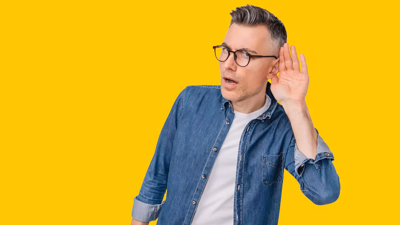 Mature Man in Casual Clothing Listening on a Yellow Background - 1280x720