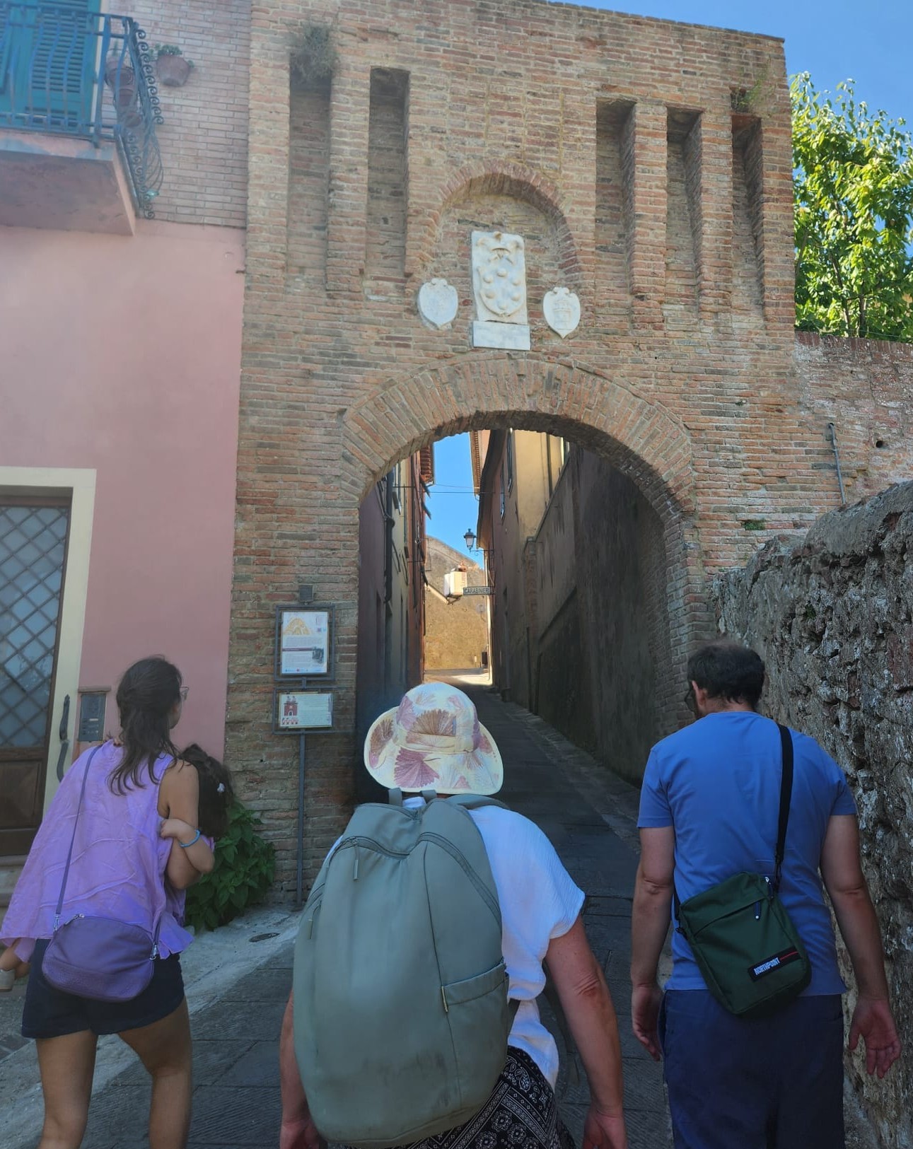 3 people walking through an arch