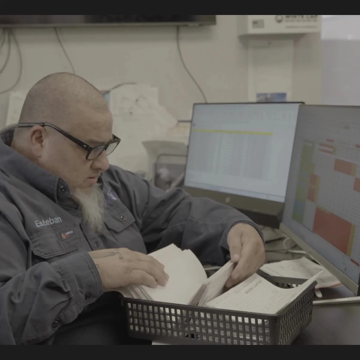 An Oilfield Administrator sorting through paper tickets